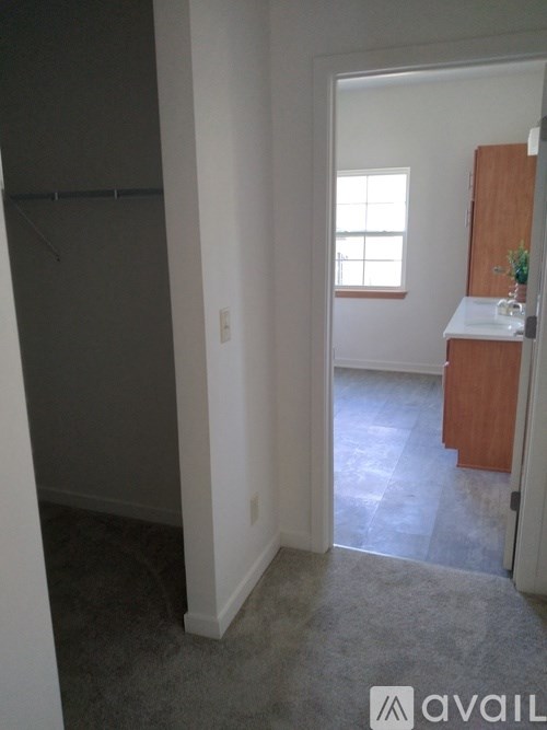 A room with a window and a wooden cabinet.