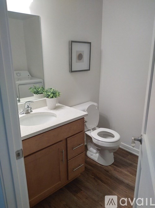 A bathroom with a toilet, sink, and mirror.