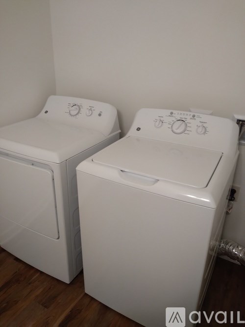 Two white front loading washing machines in a laundry room.