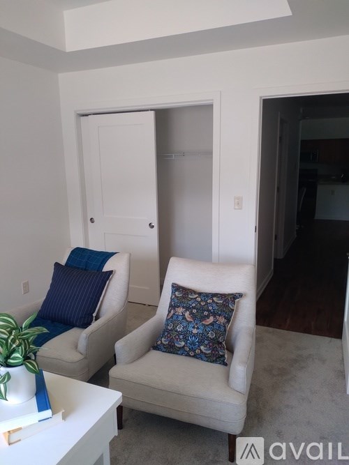 Two chairs with cushions and a table in a room.