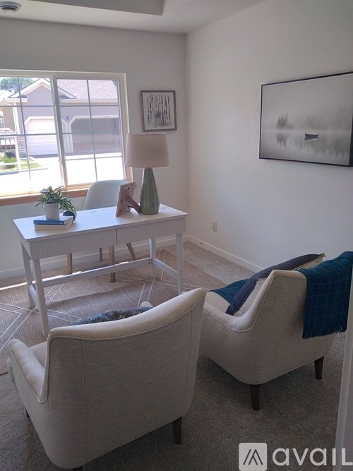 A living room with two chairs and a table.