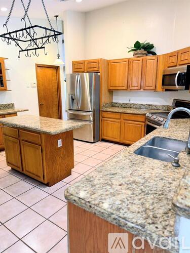 A kitchen with granite countertops and wooden cabinets.
