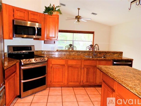 A kitchen with wooden cabinets and a granite countertop.