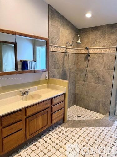 A bathroom with a tiled floor and a walk-in shower.