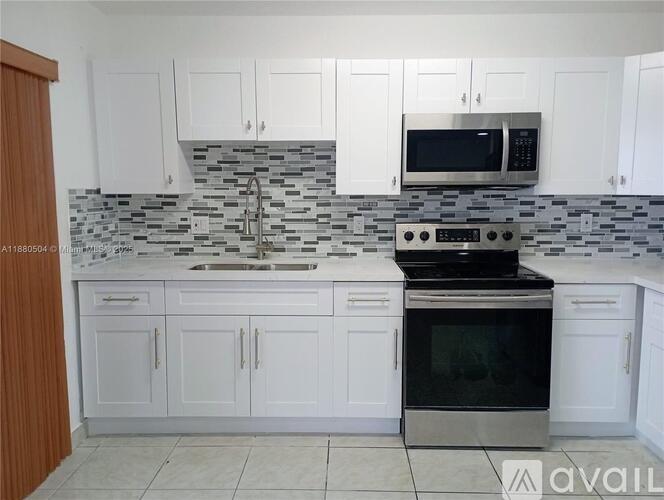 A kitchen with white cabinets and a black oven.