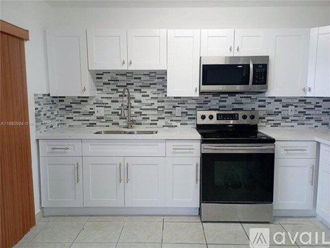 A kitchen with white cabinets and a black oven.