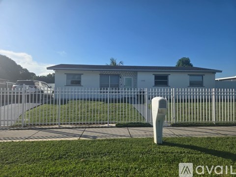 A white house with a grey fence in front of it.