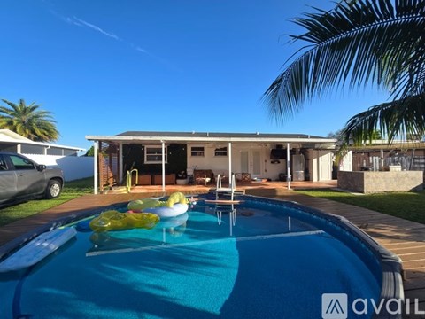 A pool with a yellow float in it and a house in the background.