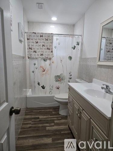A bathroom with a toilet, sink, and shower curtain.