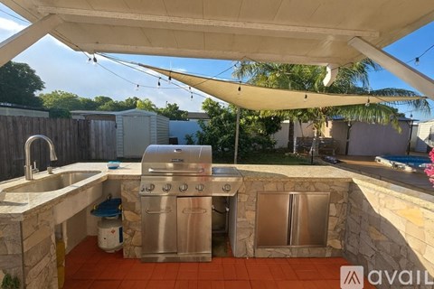 A backyard with a stone counter and a grill.
