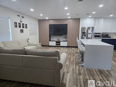 A living room with a couch, a television, and a bar area.