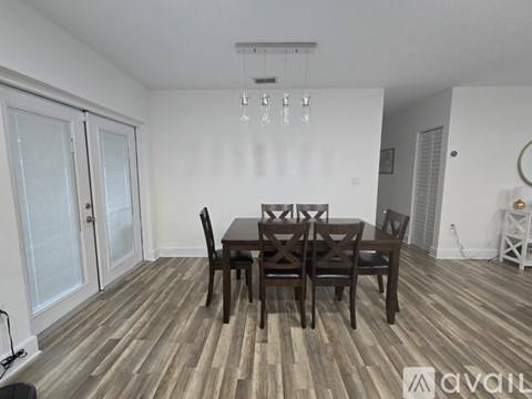 A dining room with a wooden table and chairs.