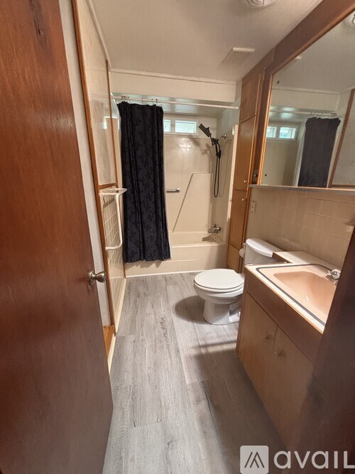 A bathroom with a toilet, sink, and mirror.