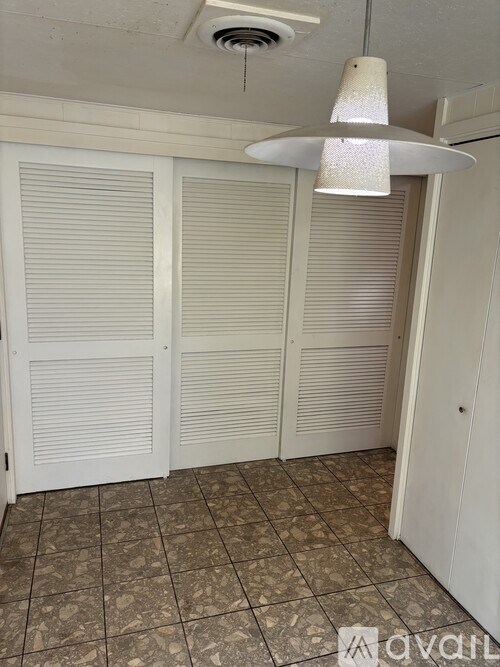 A room with a tiled floor and a hanging light fixture.