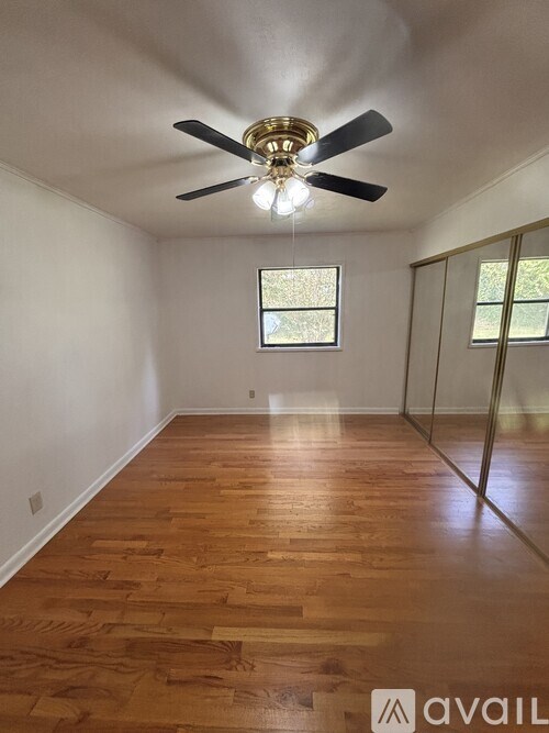 A room with wooden floors and a ceiling fan.