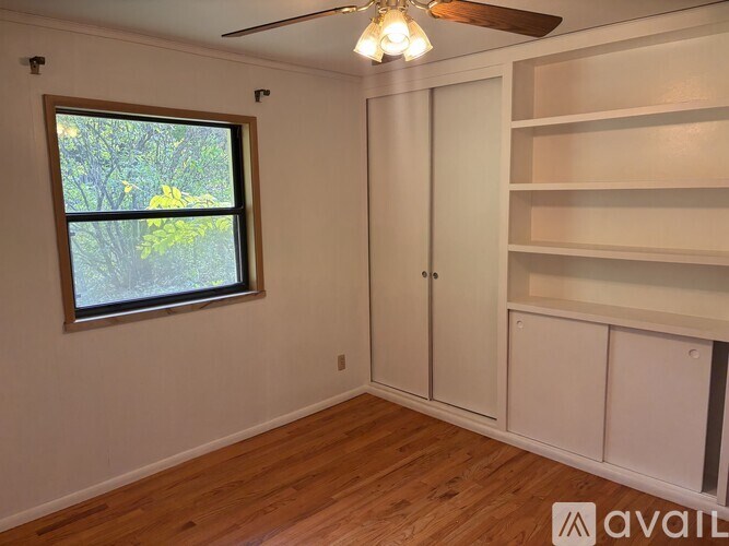 A room with a window and a fan.