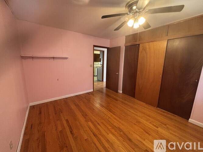 A room with wooden floors and a ceiling fan.