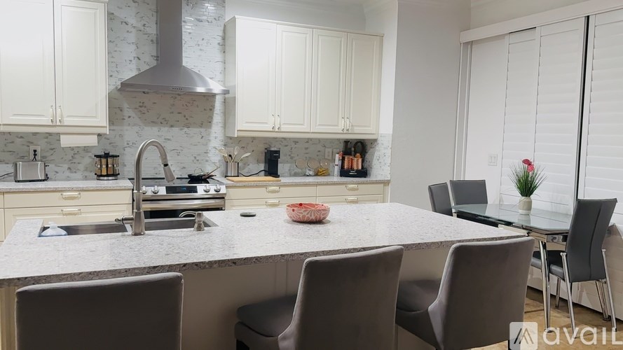 A kitchen with a marble countertop and white cabinets.