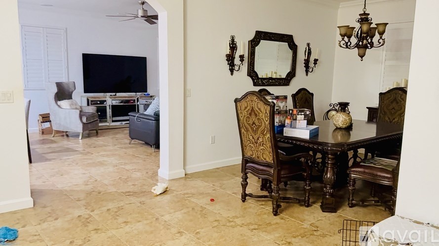 A living room with a dark wood dining table and chairs.