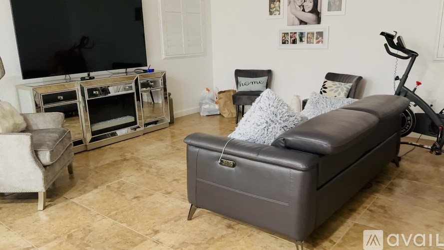 A living room with a grey sofa and a television.