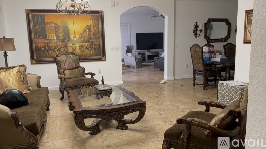 A living room with a brown sofa, a coffee table, and a painting on the wall.