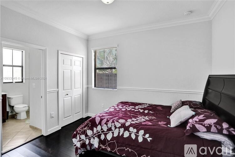 A bedroom with a bed, a toilet, and a window.