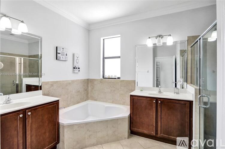 A modern bathroom with a white tub and brown wooden cabinets.