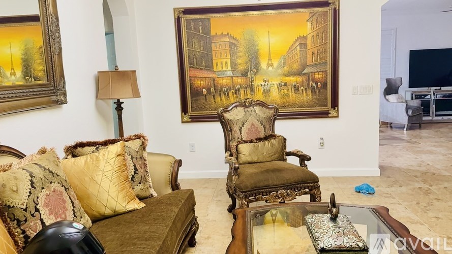 A living room with a brown sofa, a chair, and a painting on the wall.