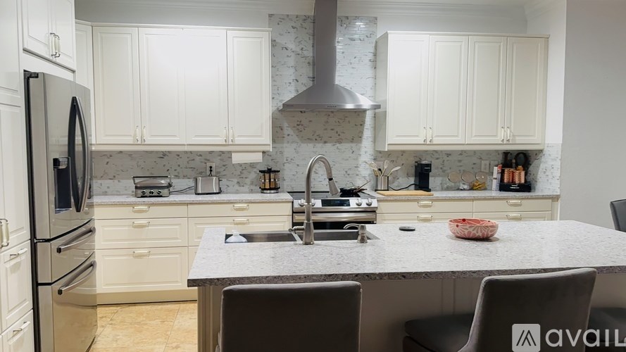 A kitchen with a marble countertop and white cabinets.