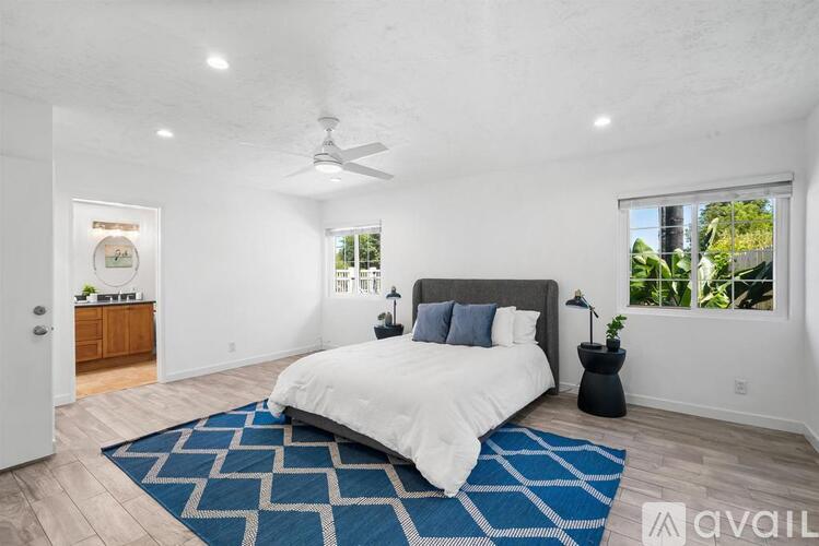 A bedroom with a large bed and a ceiling fan.