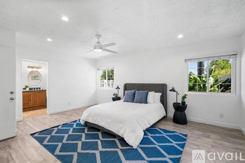 A bedroom with a large bed and a ceiling fan.
