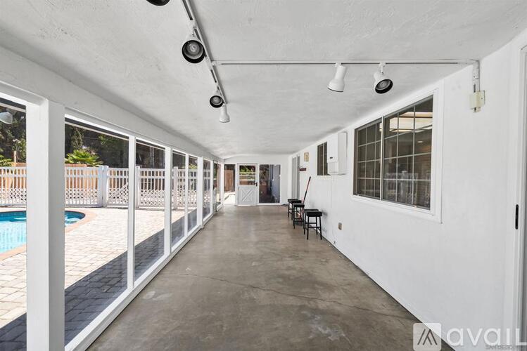 A long, empty hallway with a pool visible through the windows.