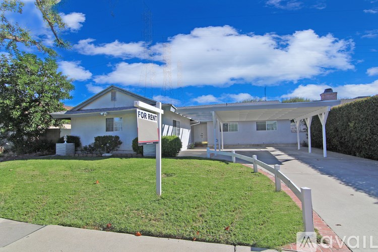 A house with a "For Rent" sign in front of it.