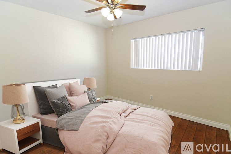 A bedroom with a bed, nightstand, and window.