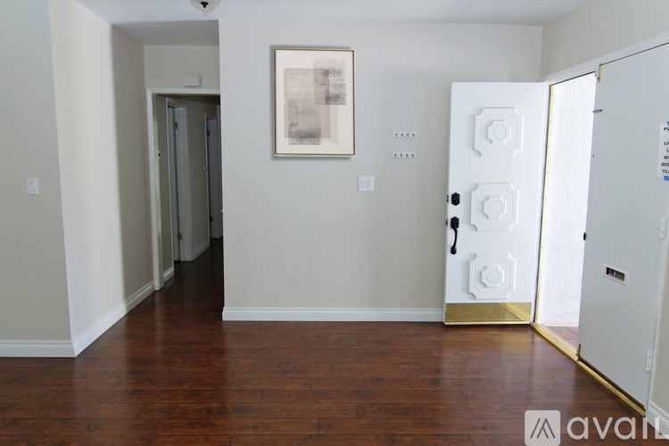 A room with a white door and a painting on the wall.