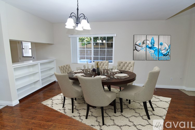 A dining room with a round table and chairs.
