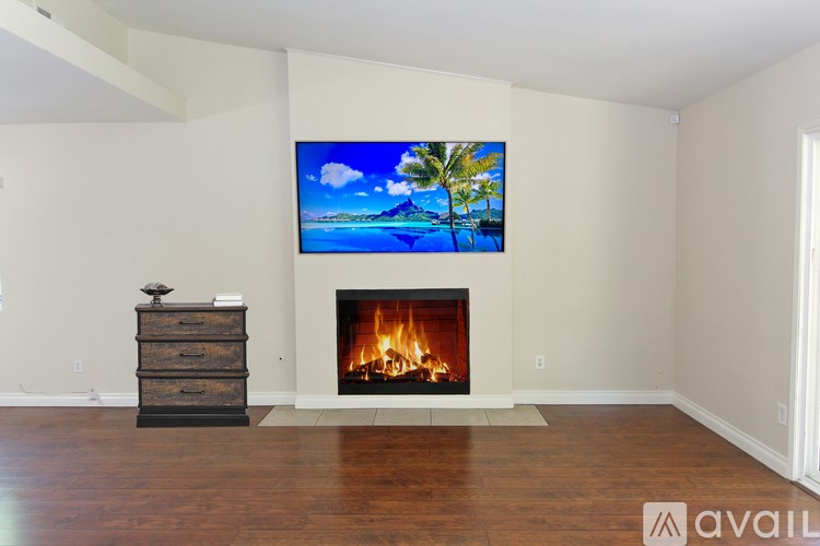 A living room with a fireplace and a painting on the wall.
