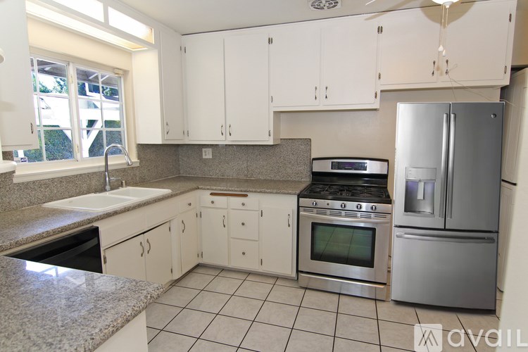 A kitchen with white cabinets and stainless steel appliances.