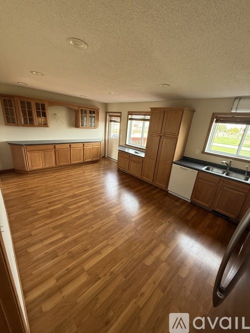 A kitchen with wooden floors and cabinets.