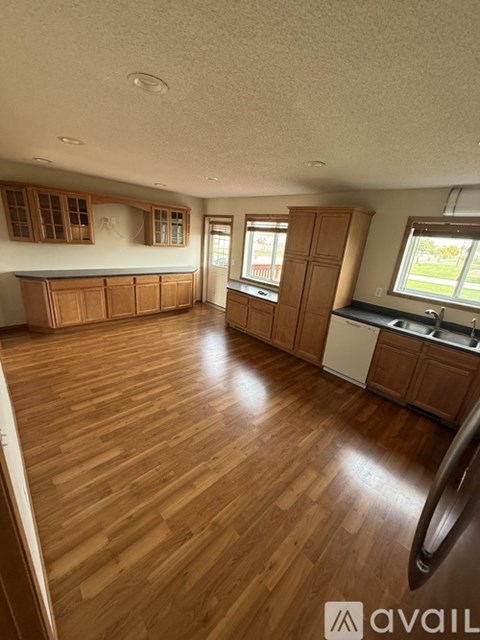 A kitchen with wooden floors and cabinets.