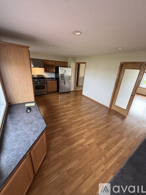 A kitchen with wooden floors and a refrigerator.