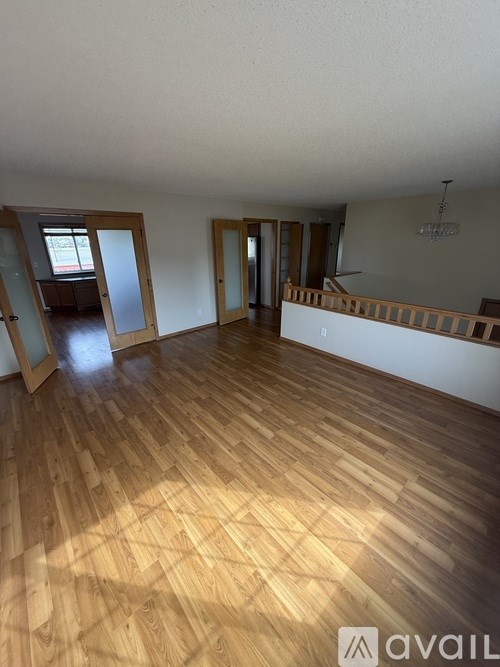 A room with wooden flooring and a balcony.