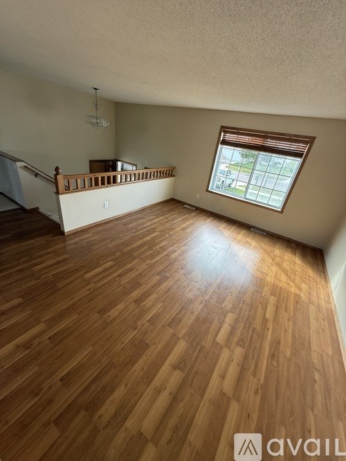 A room with wooden flooring and a window.