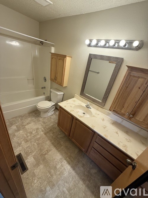 A bathroom with a toilet, sink, and mirror.
