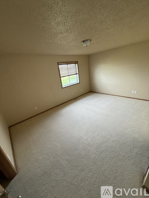 A room with a window and carpeted floor.