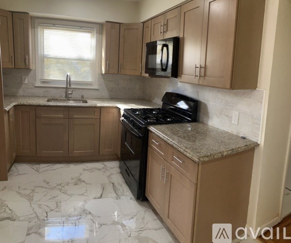 A kitchen with wooden cabinets and a marble countertop.