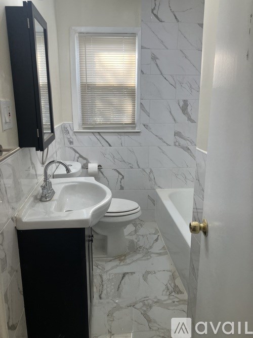 A bathroom with a sink, toilet and a window.