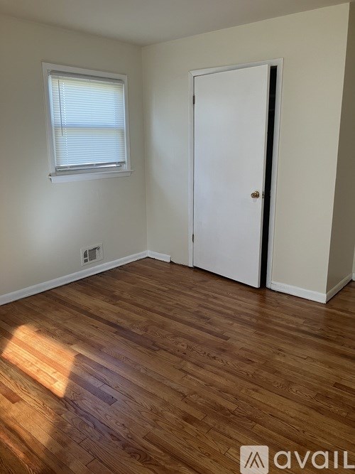 A room with a white door and a window with blinds.