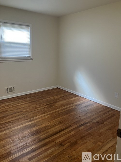 A room with wooden flooring and a window.