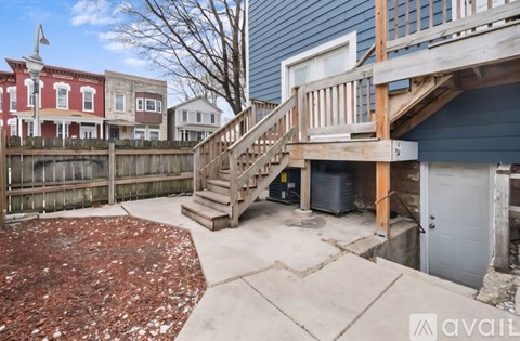 A backyard with a wooden deck and stairs leading to a garage.